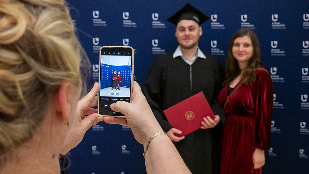 Zdjęcie absolwenta na tle wydziałowej ścianki